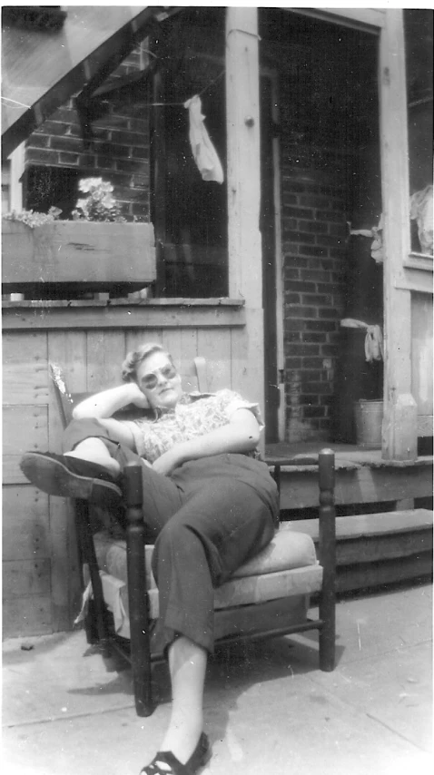 an old po of a lady resting on a chair