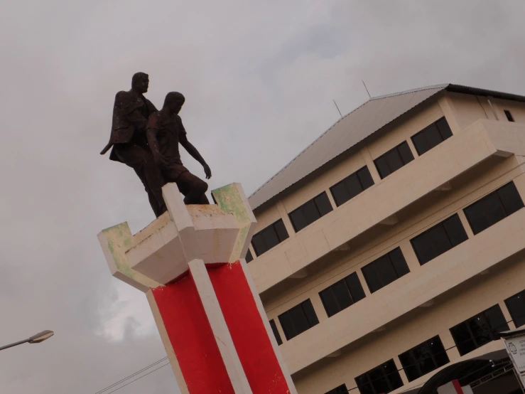 a large building with a statue in the center and another statue at the top