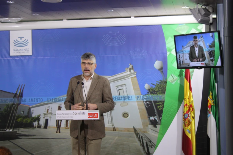 a man holding a white sign in front of a tv