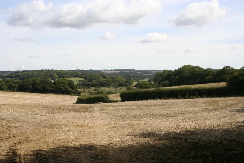 two people walking in the distance on an open field