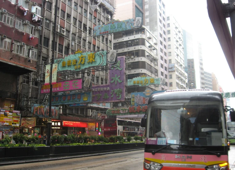 a city street with tall buildings and neon signs