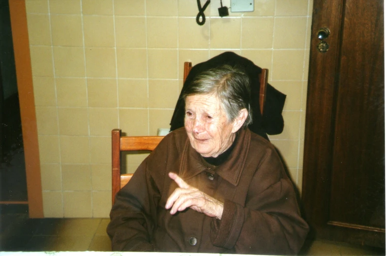 a woman with glasses is sitting and pointing