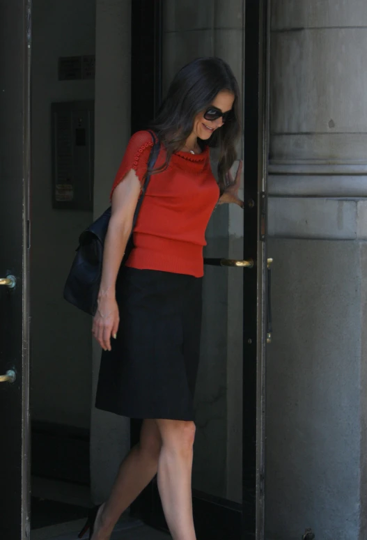 a woman walks into the doors to enter the building