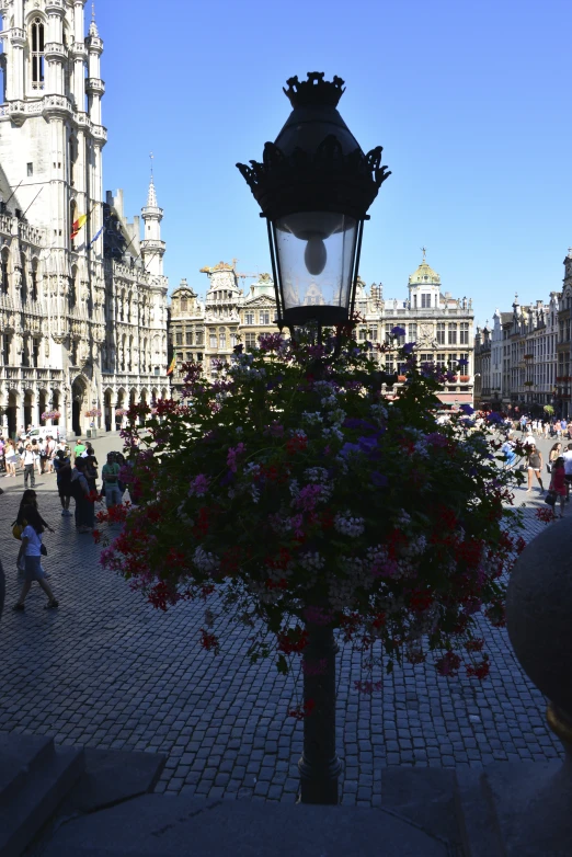 an ornate light and street lamp in a plaza