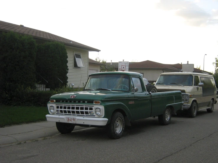 an older model pickup truck towing another older style truck