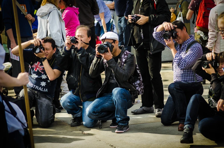 several people kneeling and standing taking pictures