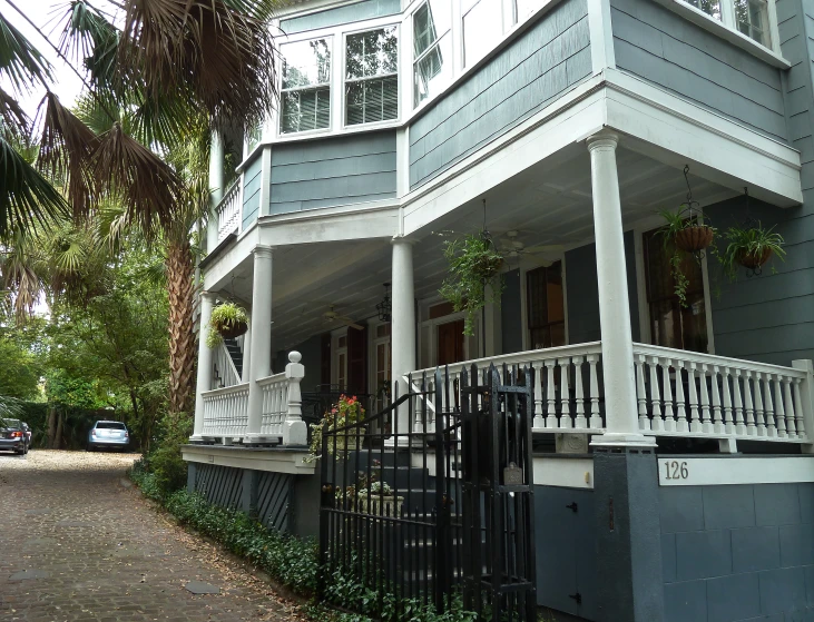 two story gray house with large porch and front verading