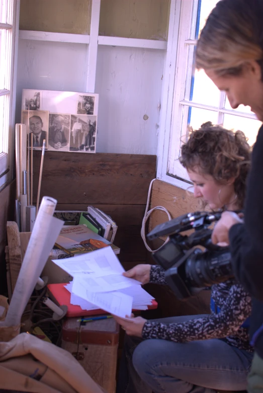 a woman is using a video camera and is filming another woman