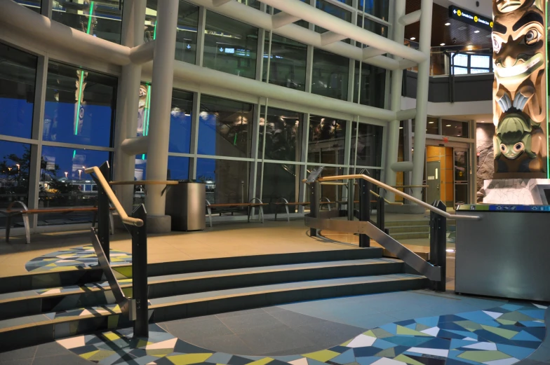 a lobby with colorful flooring and glass windows