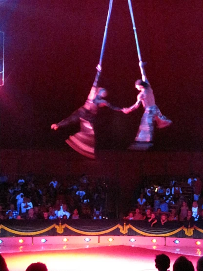 two people performing aerial aerial stunts on a stage