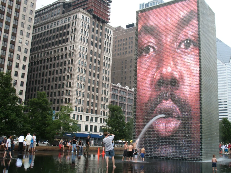 people looking at the large mural on the side of a building