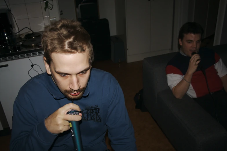 two men in a living room looking at soing