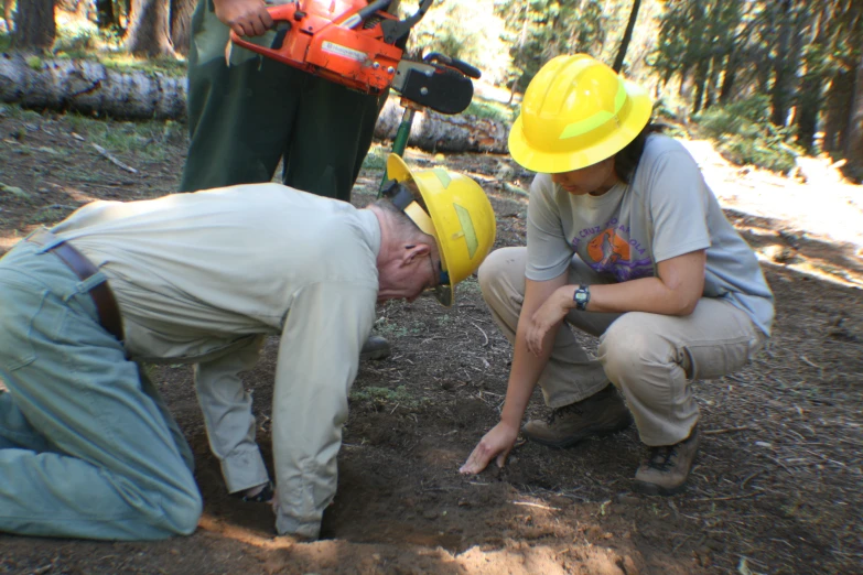 two men working with construction equipment on the ground