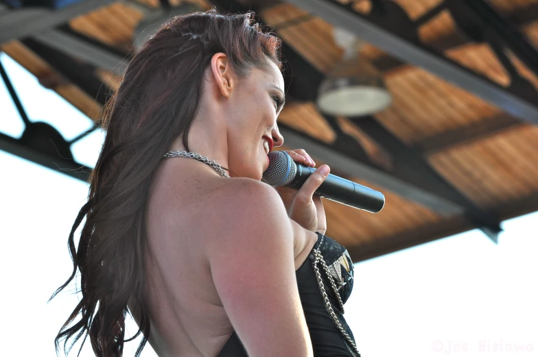 a woman wearing a halter top holding a microphone