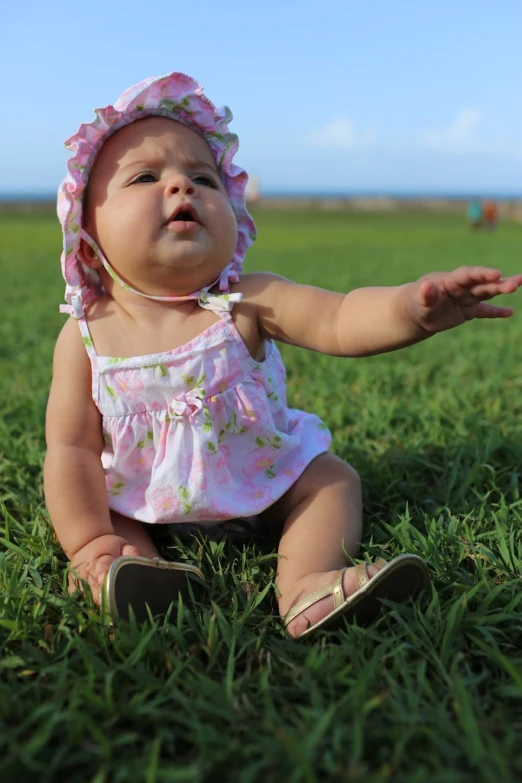 a little girl that is sitting in the grass