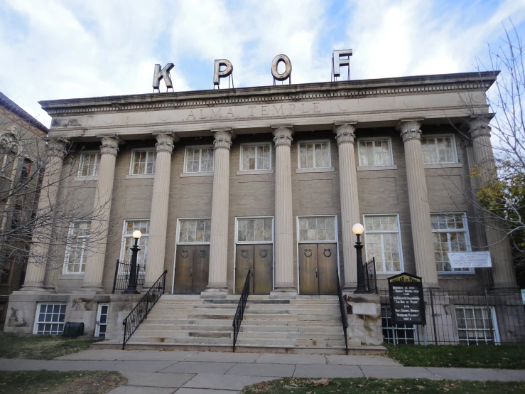 an old grey brick building with large pillars