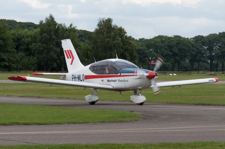 a small airplane landing on the runway in an open area
