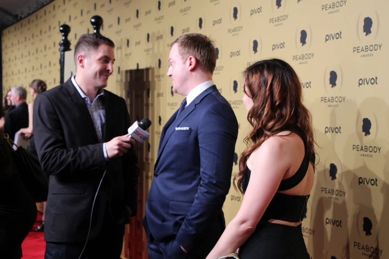 a man talking to two women at an event