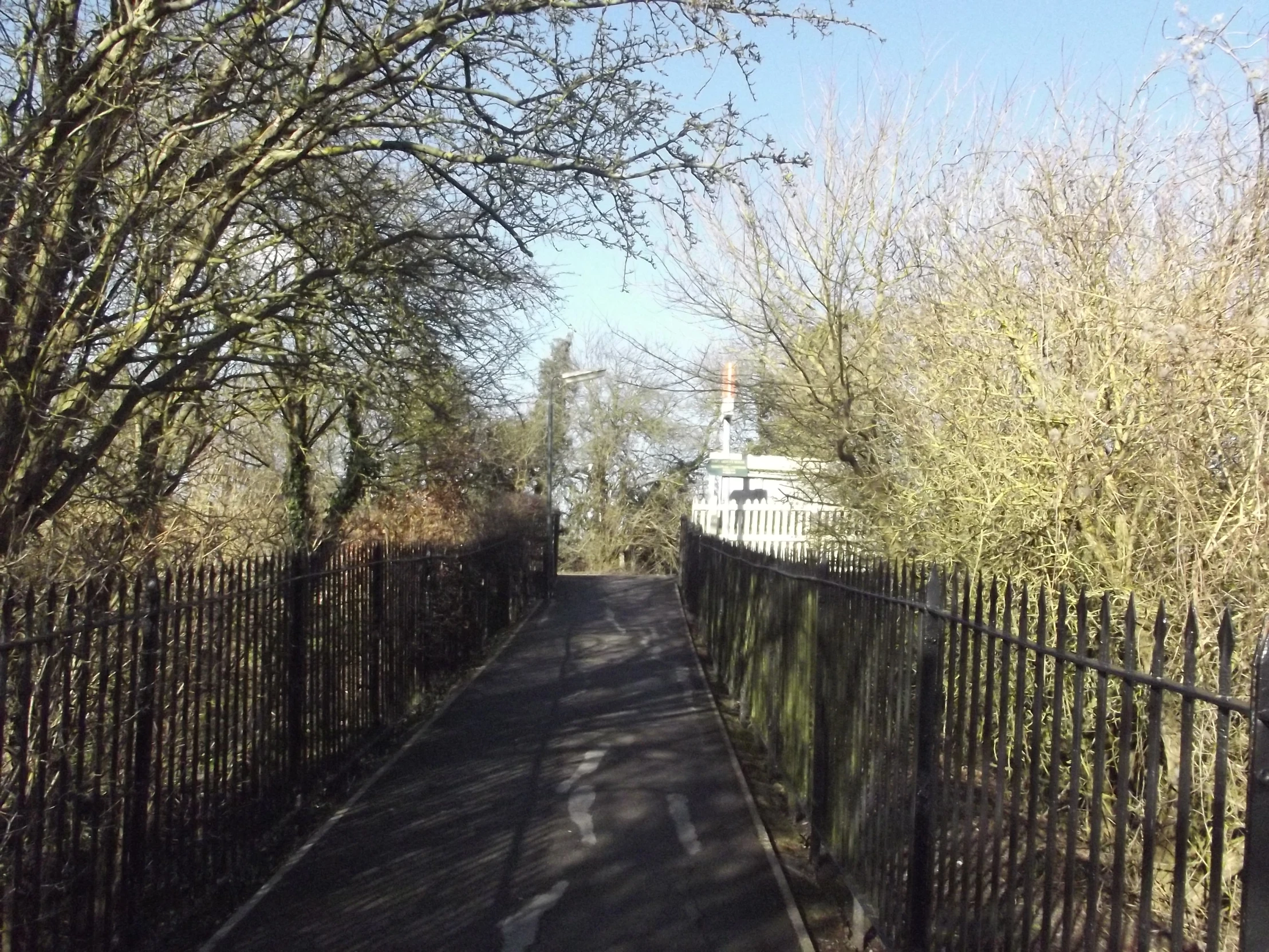 an empty street next to a small church with a fence