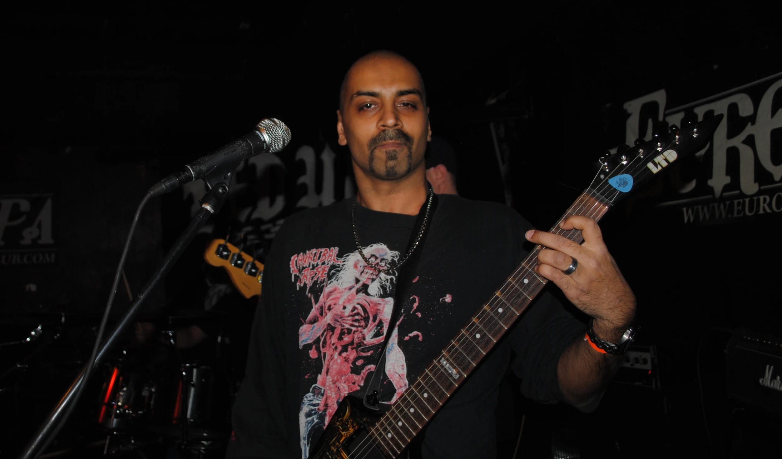 a man holding up his guitar on the stage