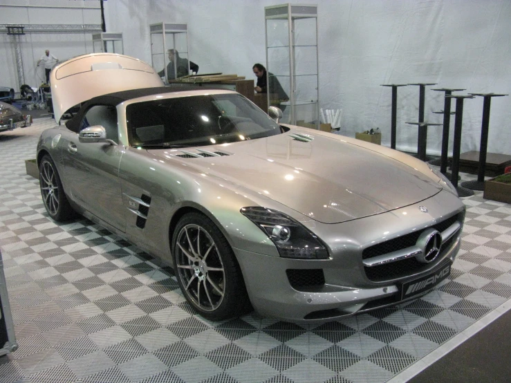 a silver sports car is on display in a showroom