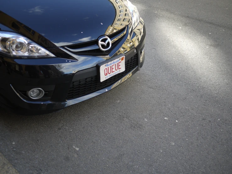 a black car with a gold emblem is on the street