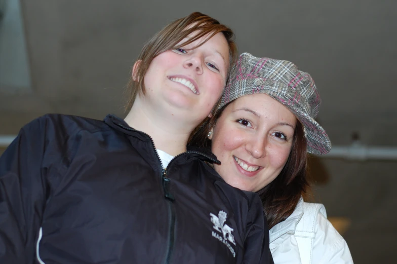 two girls wearing hats standing next to each other