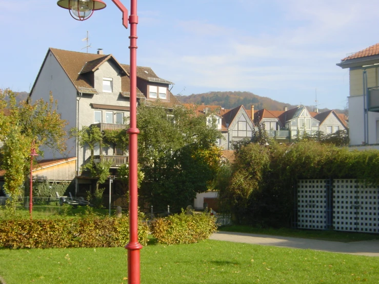 a pole with street lights stands in the middle of a lawn