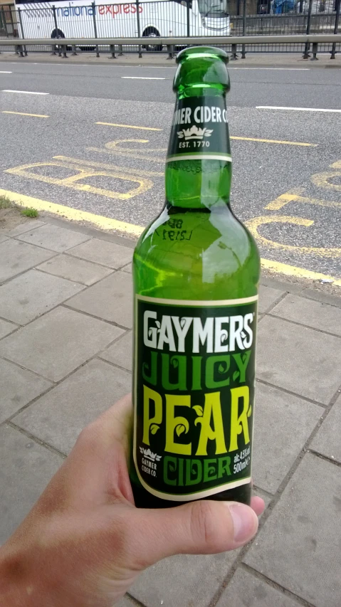 the bottle of beer is green on the pavement