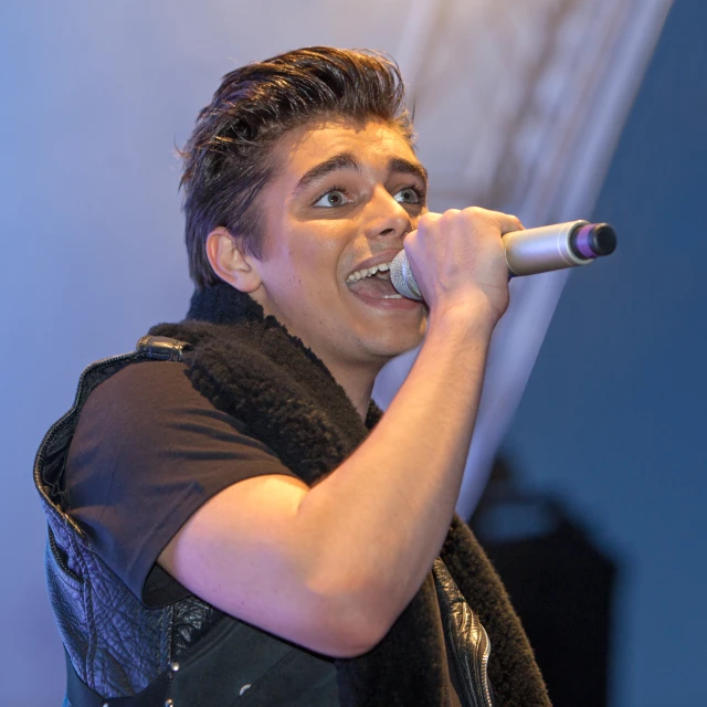 a male in a black shirt is holding a microphone