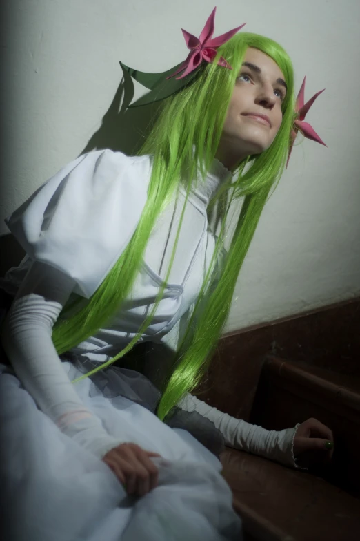 a person with green hair wearing white and pink flowers