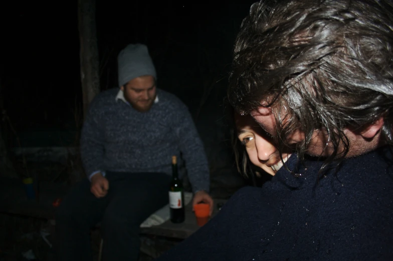 two people standing around some bottles of wine