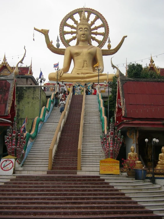 there is a large golden statue sitting above some stairs