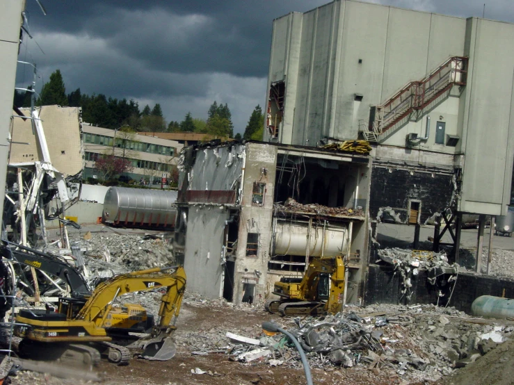 a group of rubble in front of a building with a machinery and construction equipment inside