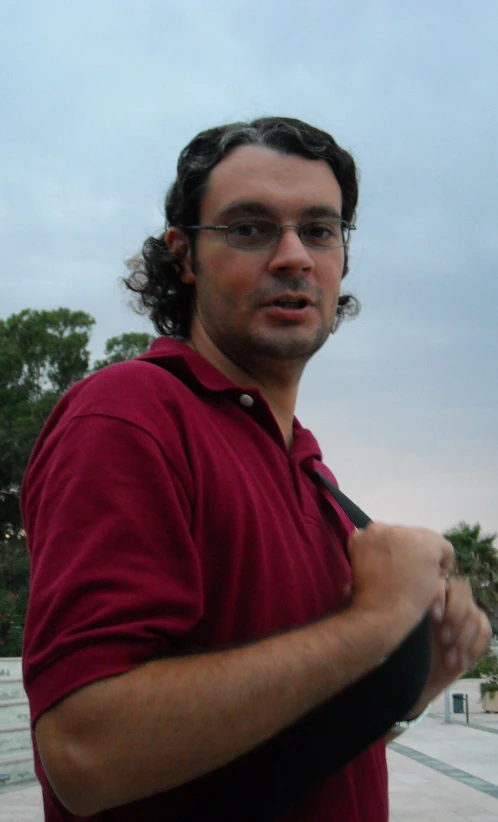 a man in a red polo shirt looking away