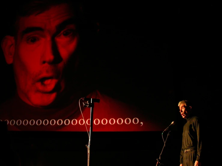 a man on stage speaking into microphones