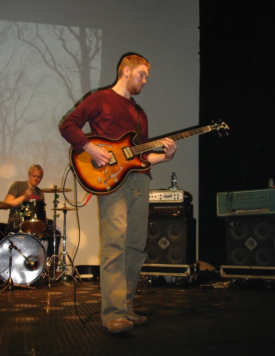 a man is playing a guitar in front of a group of men