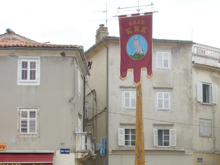 an old flag pole with a banner in the middle of a street