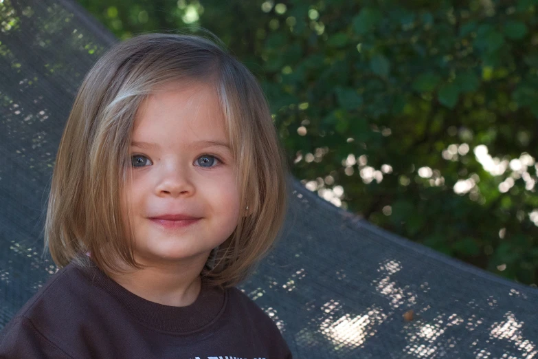 a little girl is smiling and holding an umbrella