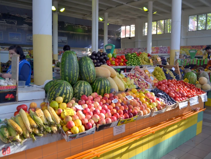 a display of assorted produce is under large pillars