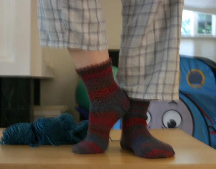 a person standing next to a pile of yarn on a table