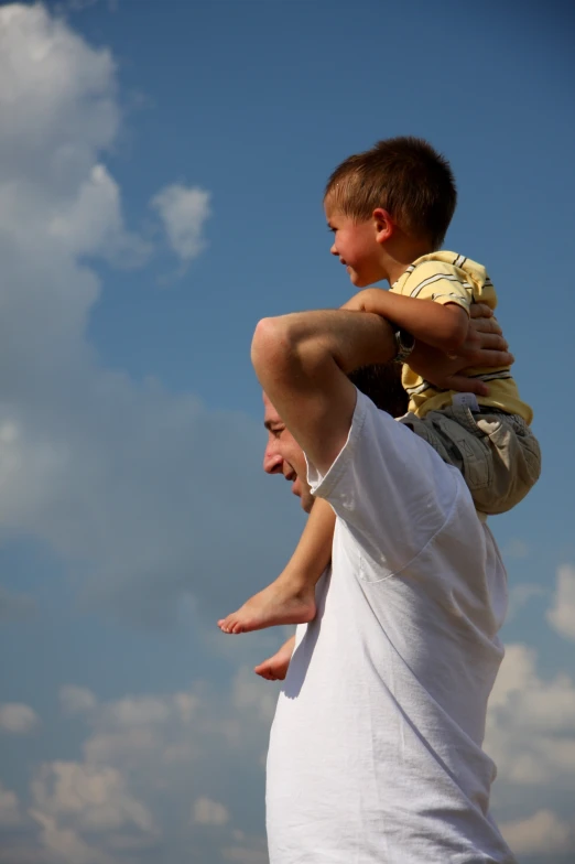 a father is lifting his son into the air