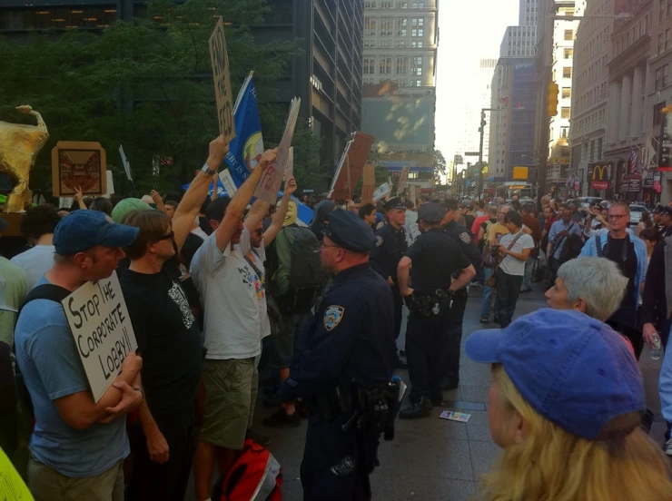 a crowd of people holding flags and signs in the street