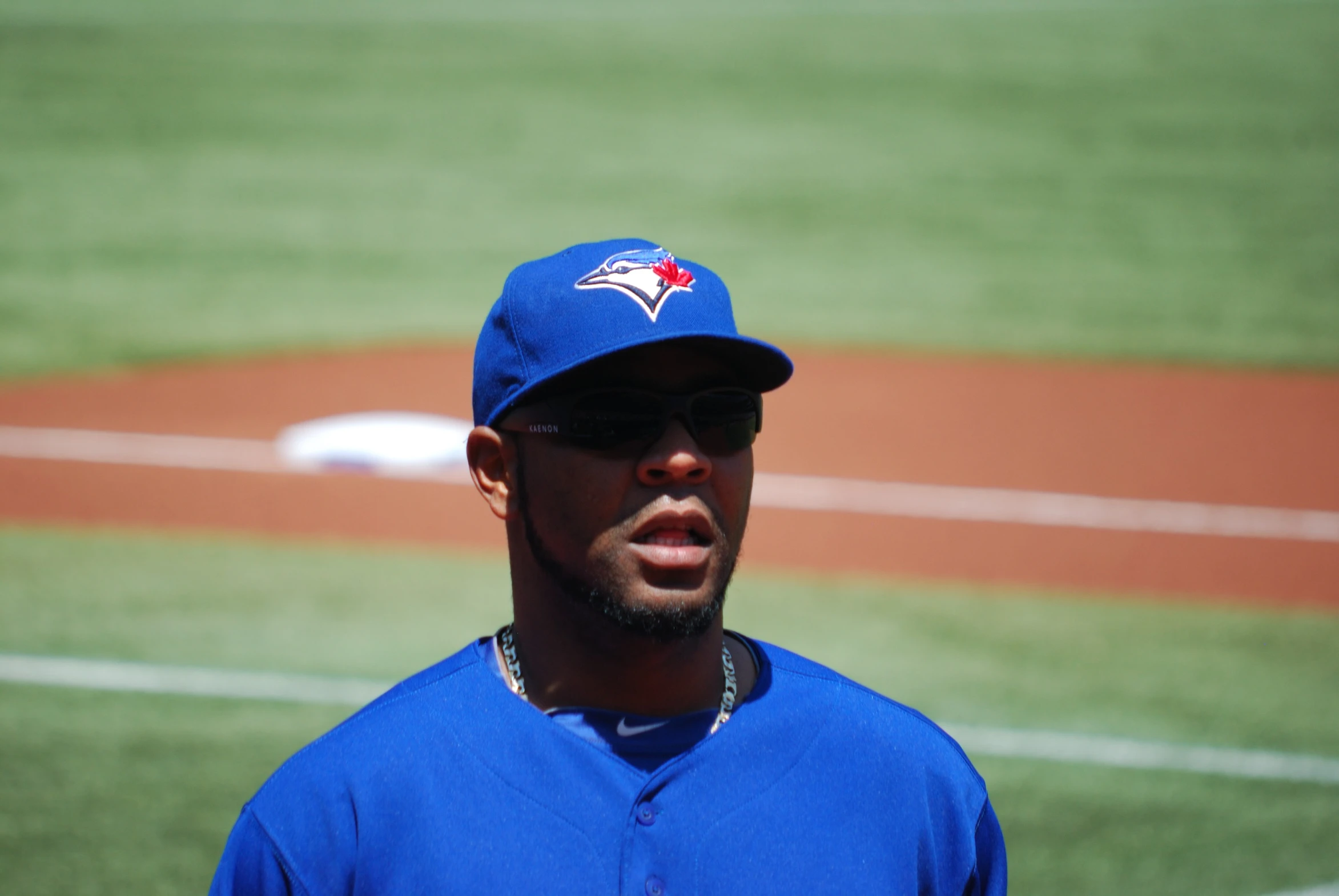 a man with a blue baseball cap is looking at a baseball field