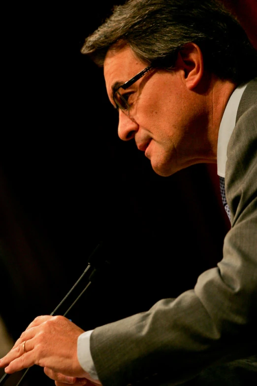 a man is sitting at a table holding a microphone