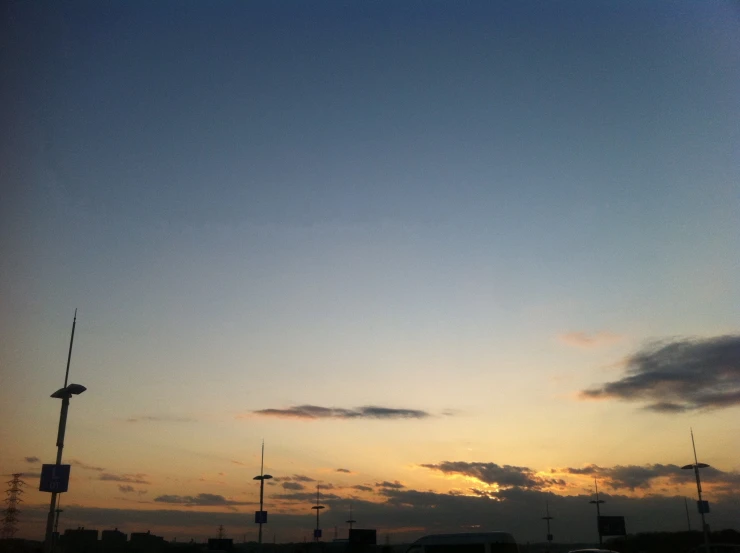 a few cars drive down a road at sunset