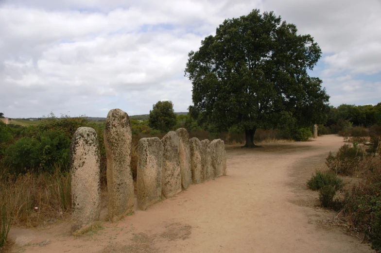 a long road is running between some stone pillars