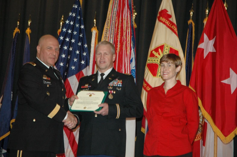 a man and woman in uniform are holding an award