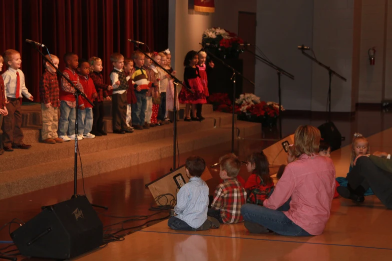 an audience in the auditorium watching a group of children