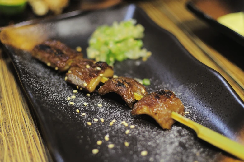 food being prepared on a black plate with a fork